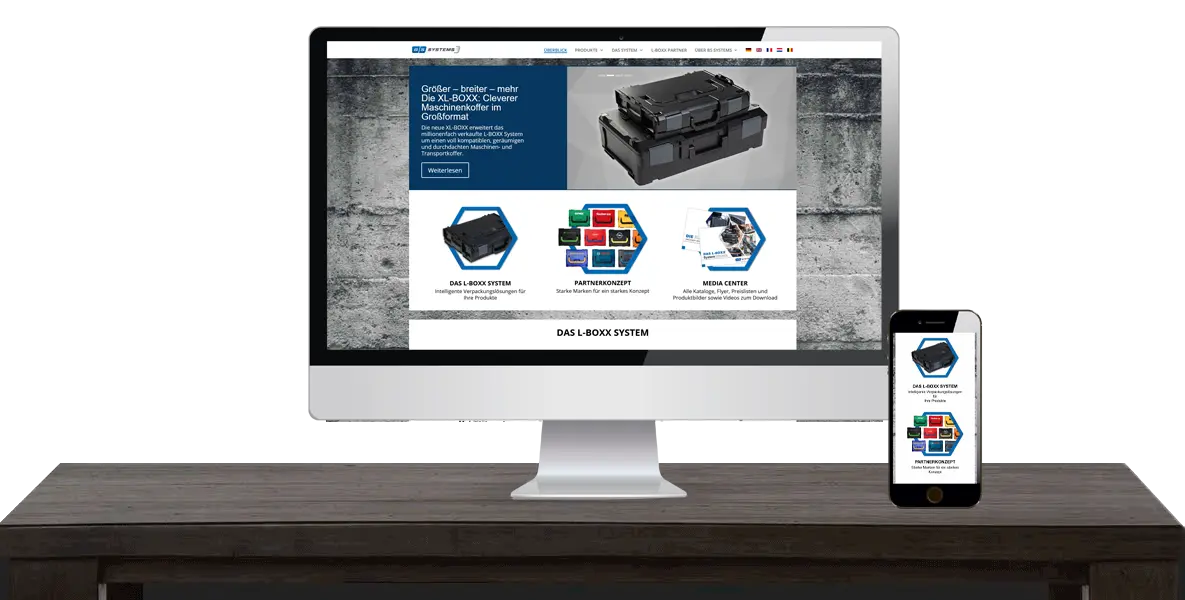 Ein Computermonitor und ein Smartphone zeigen auf einem Holzschreibtisch dieselbe Website für Industrieprodukte an.