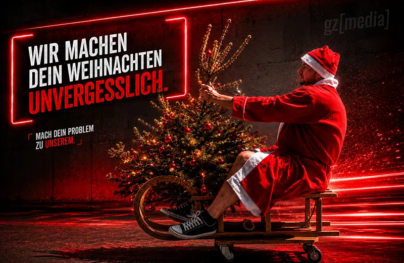 Ein flauschiges rotes Monster mit großen Augen steht neben einem Geschenk, im Hintergrund sind festliche Lichter verschwommen.